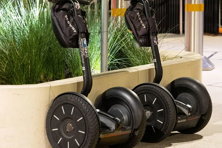 Twee segways staan dicht bij elkaar geparkeerd in een buitenruimte.