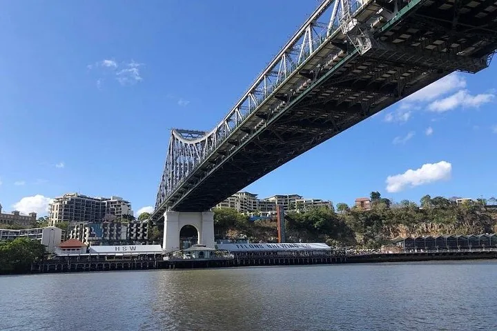 Eine große Stahlbrücke, die sich über einen breiten Fluss spannt.