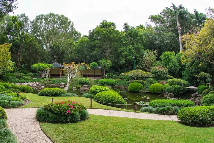 Ein ruhiger Garten im japanischen Stil mit einem Teich und Bäumen.